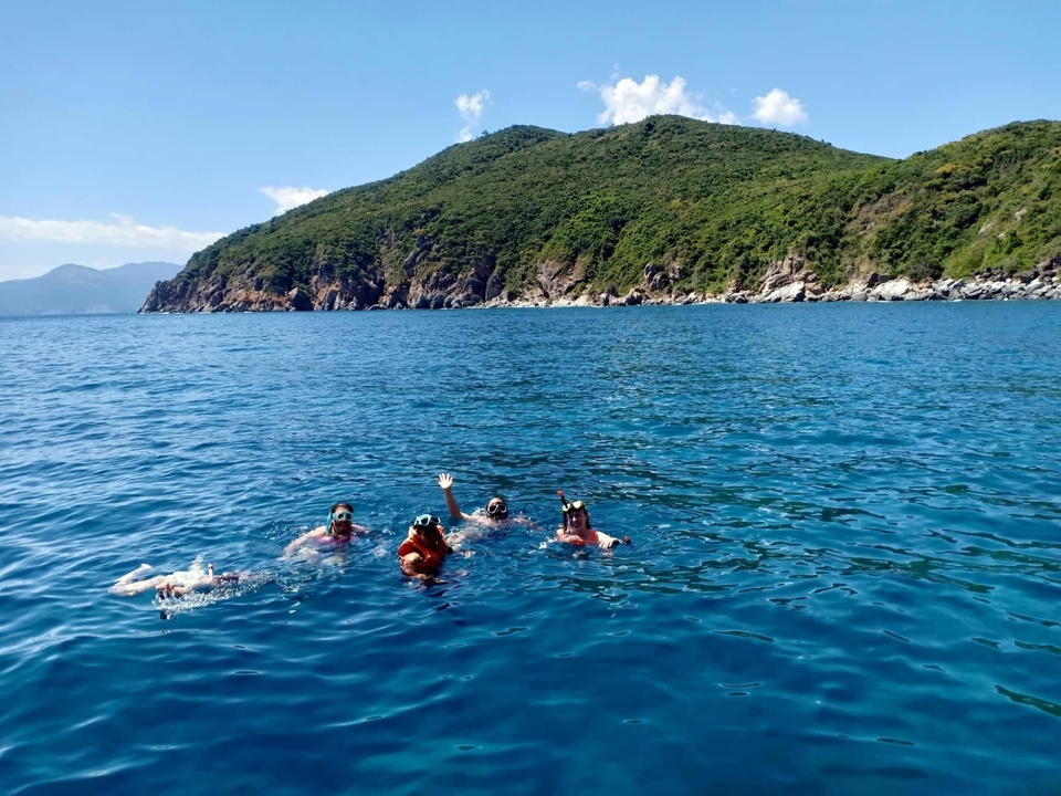 Des gens qui font de la plongée avec tuba dans une mer bleue claire.