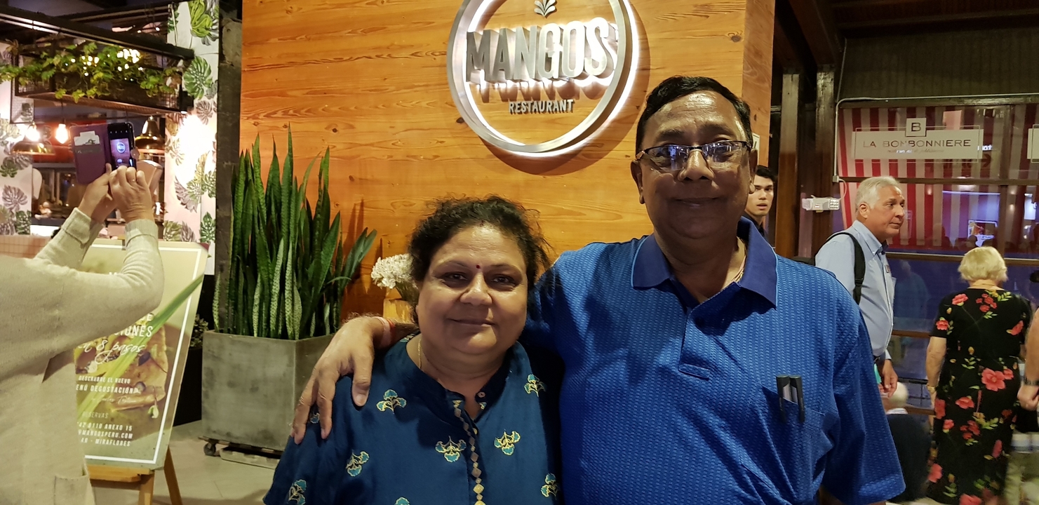 Deux personnes debout devant un panneau au restaurant Mango's.