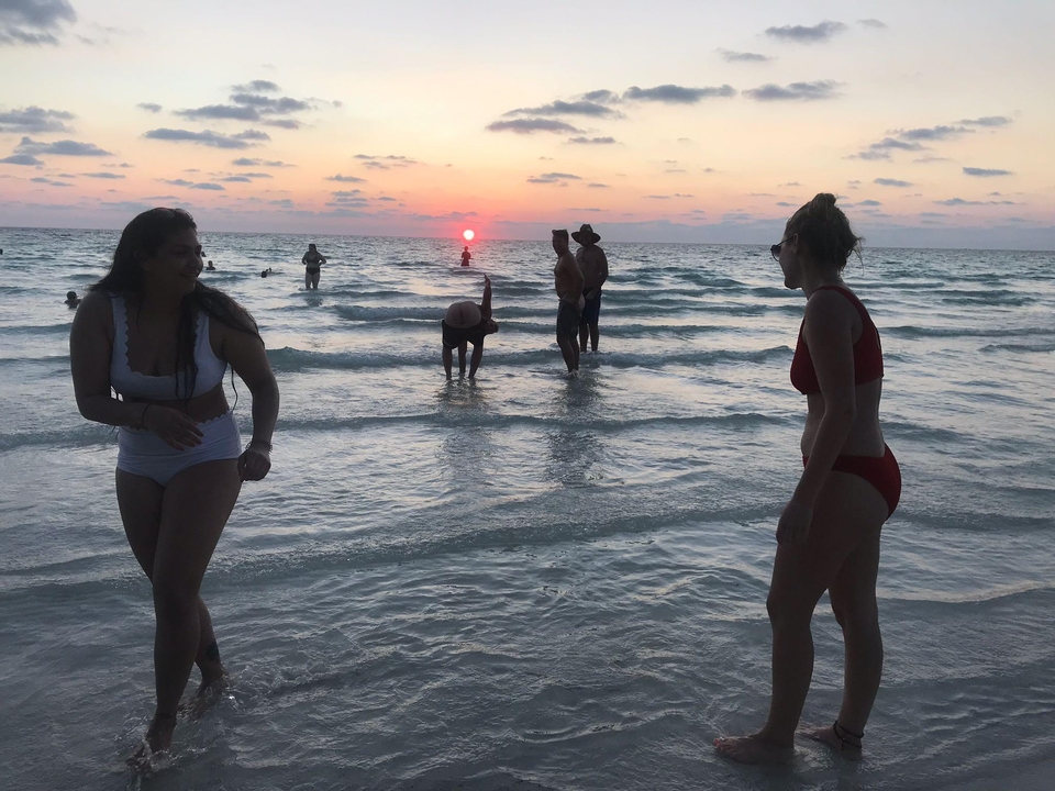 People enjoying the beach at sunset.