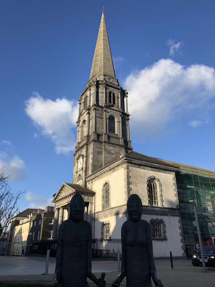 Un bâtiment en pierre avec une tour d'horloge contre un ciel dégagé.