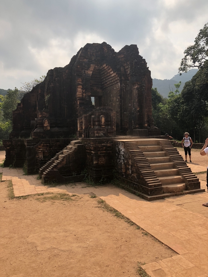 Ruines d'un temple antique avec une personne à l'arrière-plan.