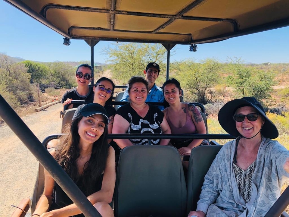 Groupe de personnes dans un véhicule de safari dans un environnement sauvage.