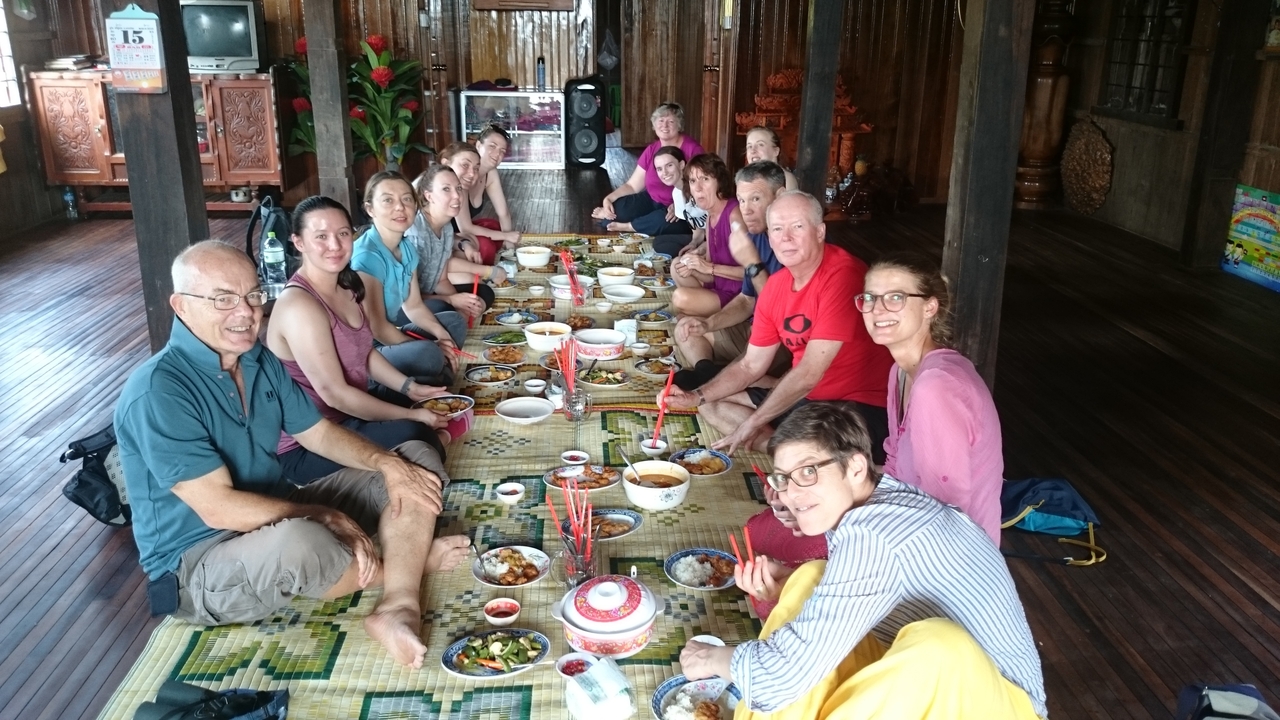 Groupe de personnes profitant d'un repas à l'intérieur avec une décoration traditionnelle.