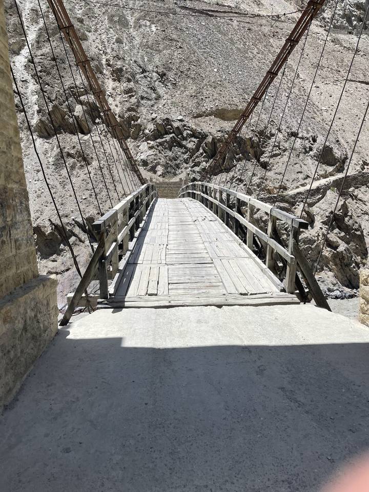View of a suspension bridge over dry rocky area.