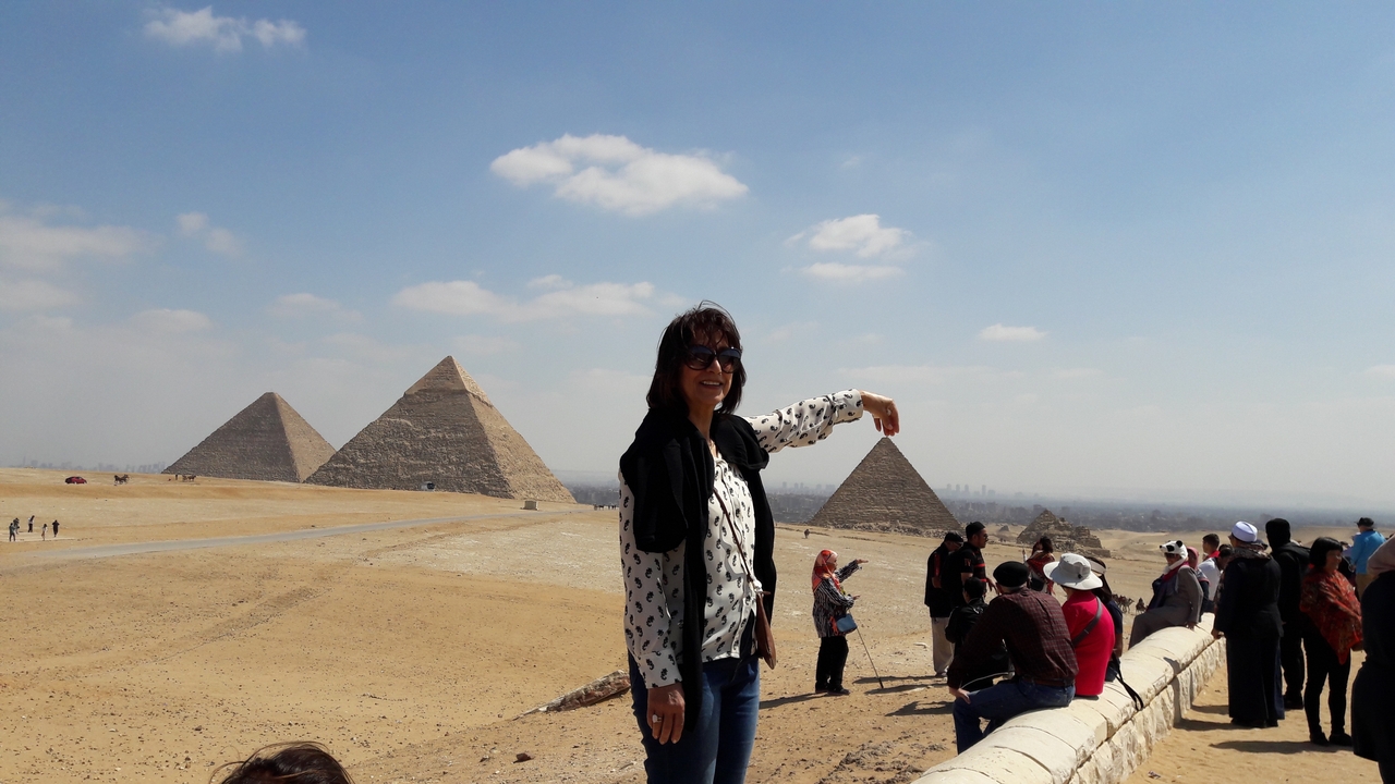 Femme posant avec des pyramides en arrière-plan.