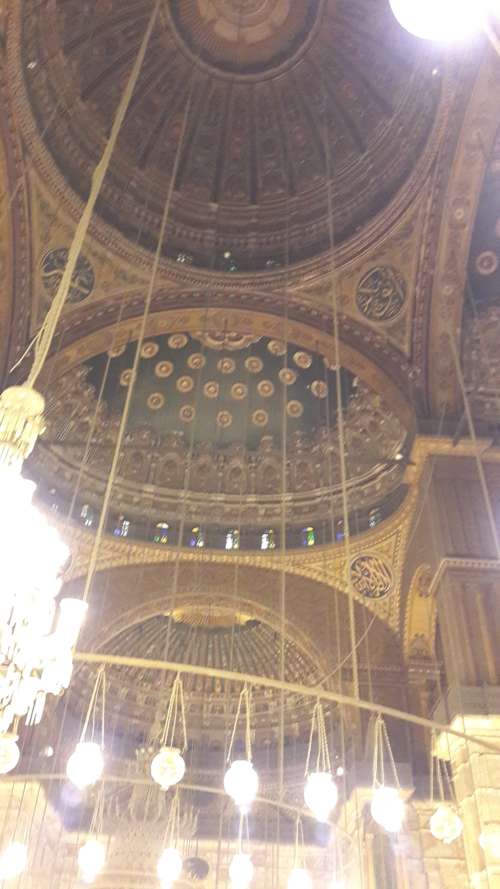 Plafond et intérieur d'un bâtiment historique aux motifs complexes.