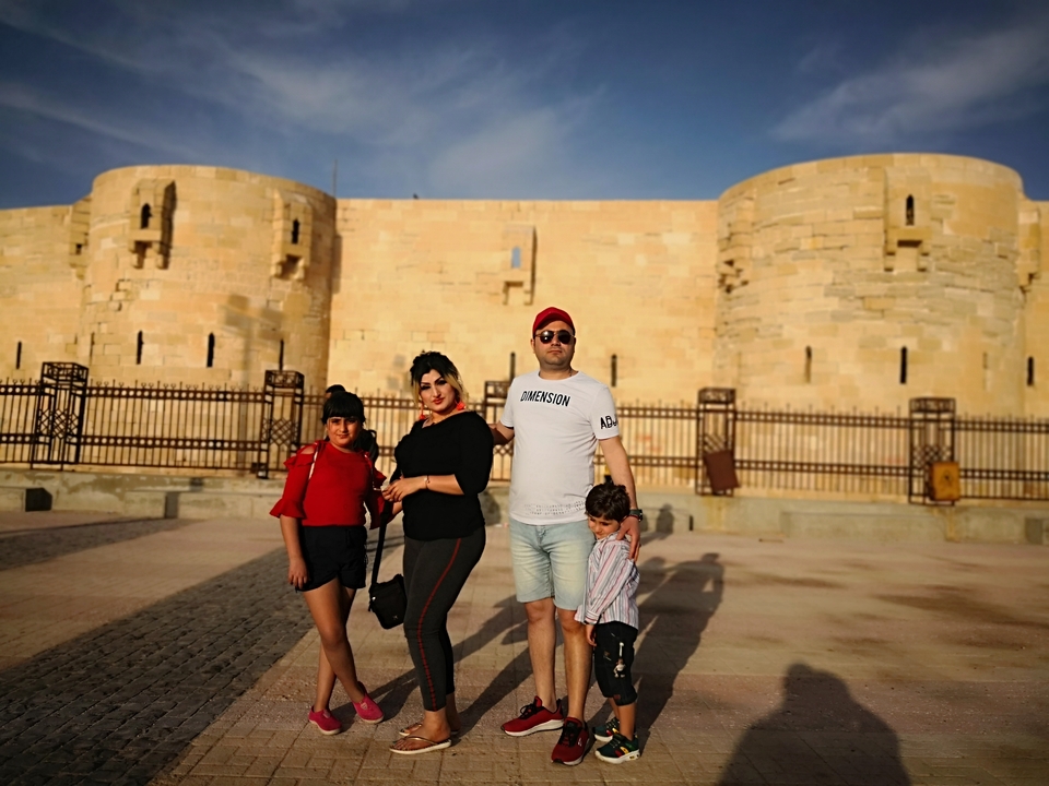 Une famille qui pose devant une forteresse historique.