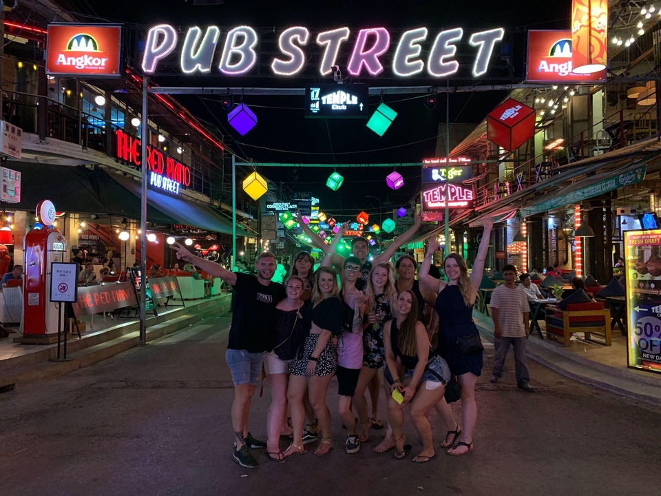 Groupe de personnes dans un quartier de vie nocturne animé la nuit.