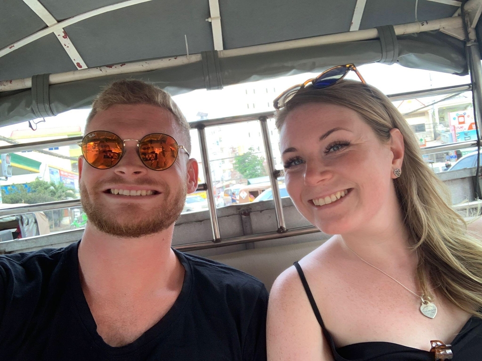 Deux personnes assises dans un véhicule en souriant.