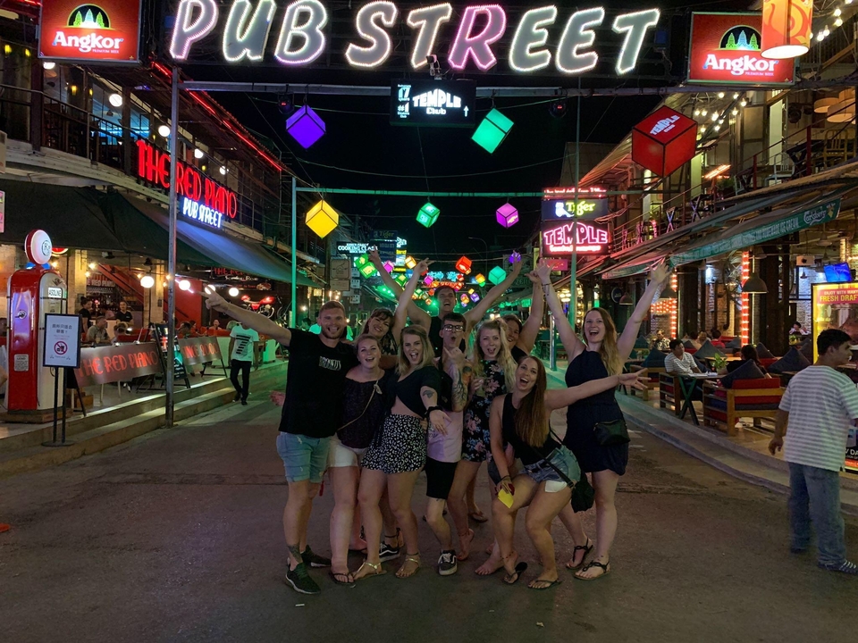 Groupe de personnes dans un quartier de vie nocturne animé la nuit.