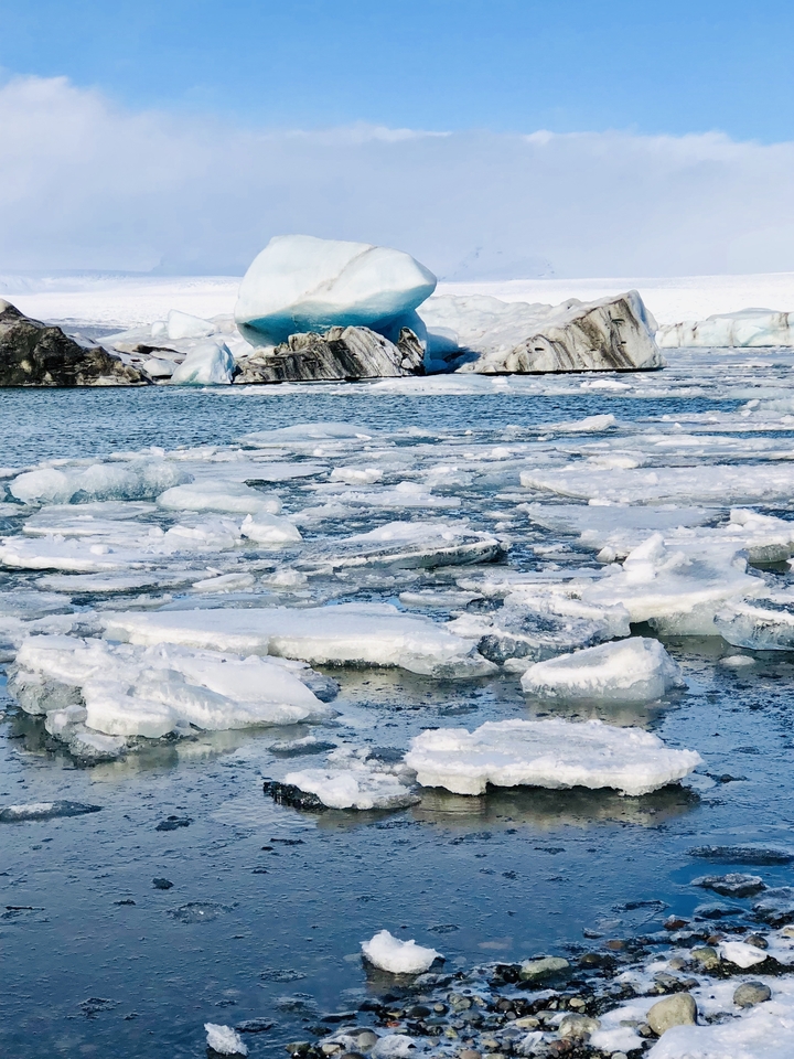 Ice formations floating in crystal clear water.