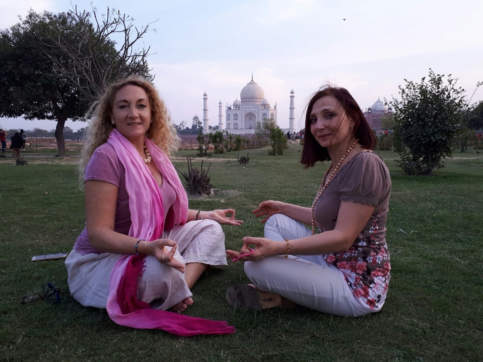 Deux personnes méditant avec le Taj Mahal en arrière-plan.