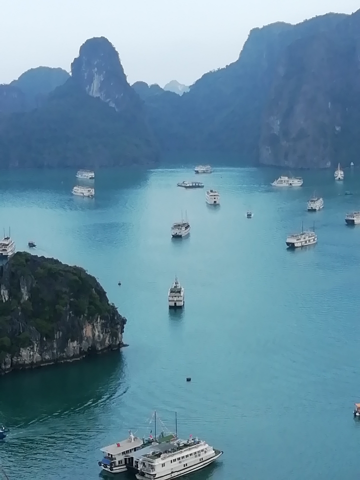 De nombreux bateaux flottant sur une baie calme.