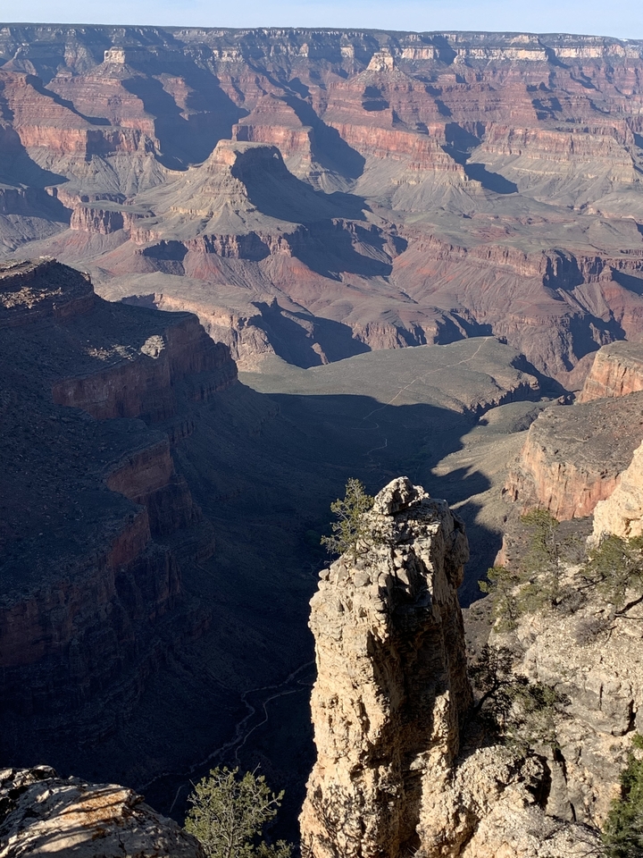 Vue du Grand Canyon avec des falaises ensoleillées et des ombres.