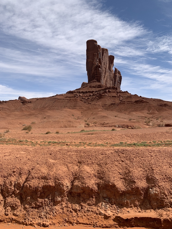 Grande formation rocheuse isolée dans un environnement désertique.