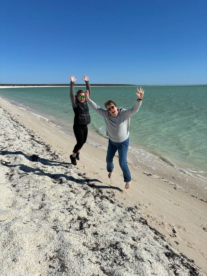 Deux personnes posant joyeusement sur une plage.