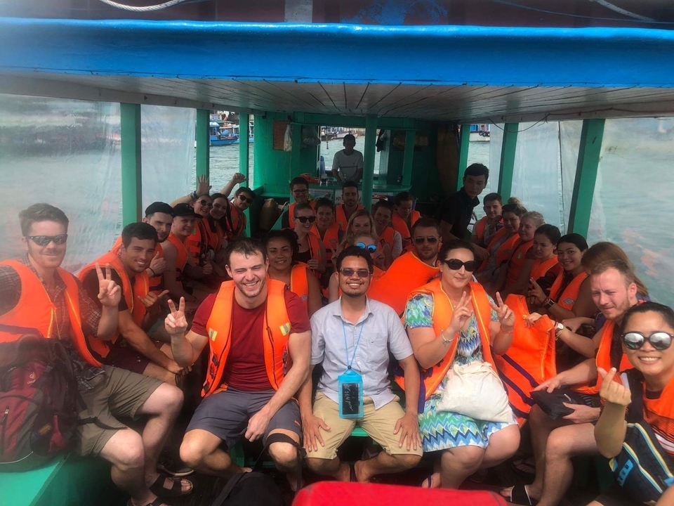 Un grand groupe sur un bateau portant des gilets de sauvetage.