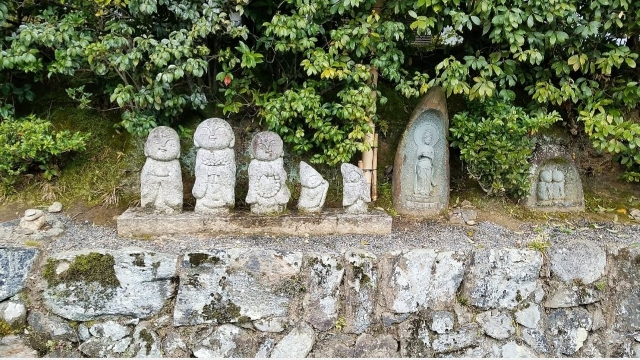 Rock garden with various stone statues and a lush background.
