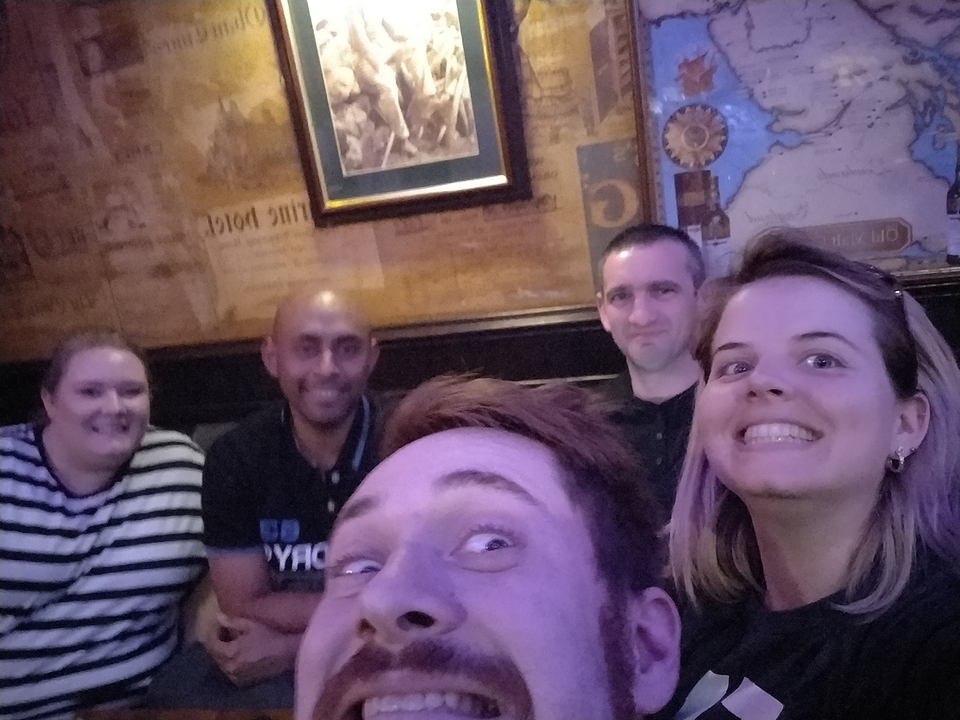 Groupe de personnes souriantes dans un pub.