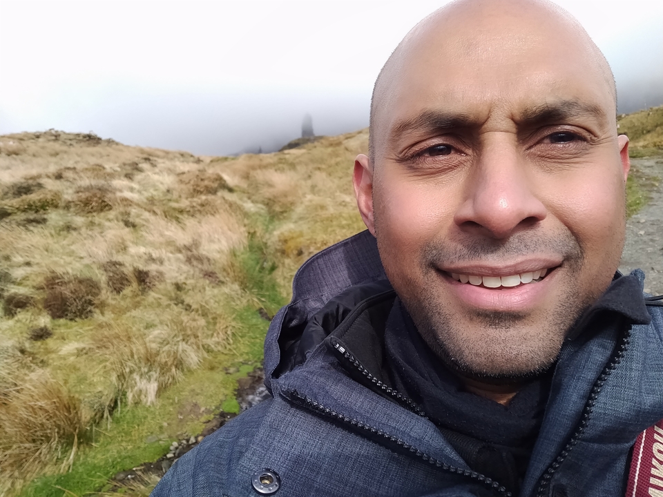 Selfie en gros plan avec un paysage brumeux en arrière-plan.