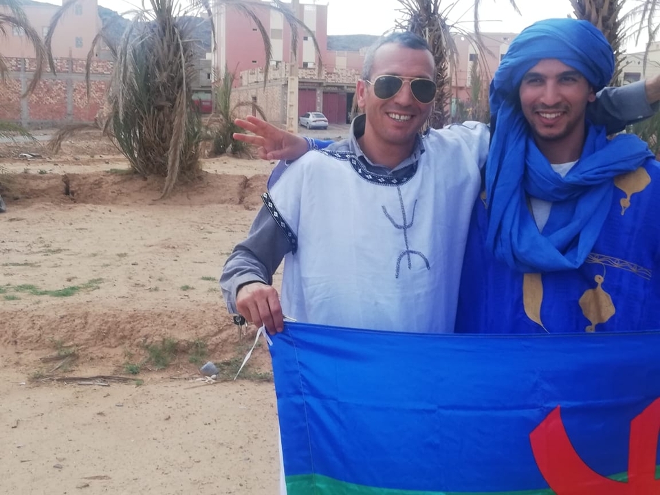 Two people posing with a flag.