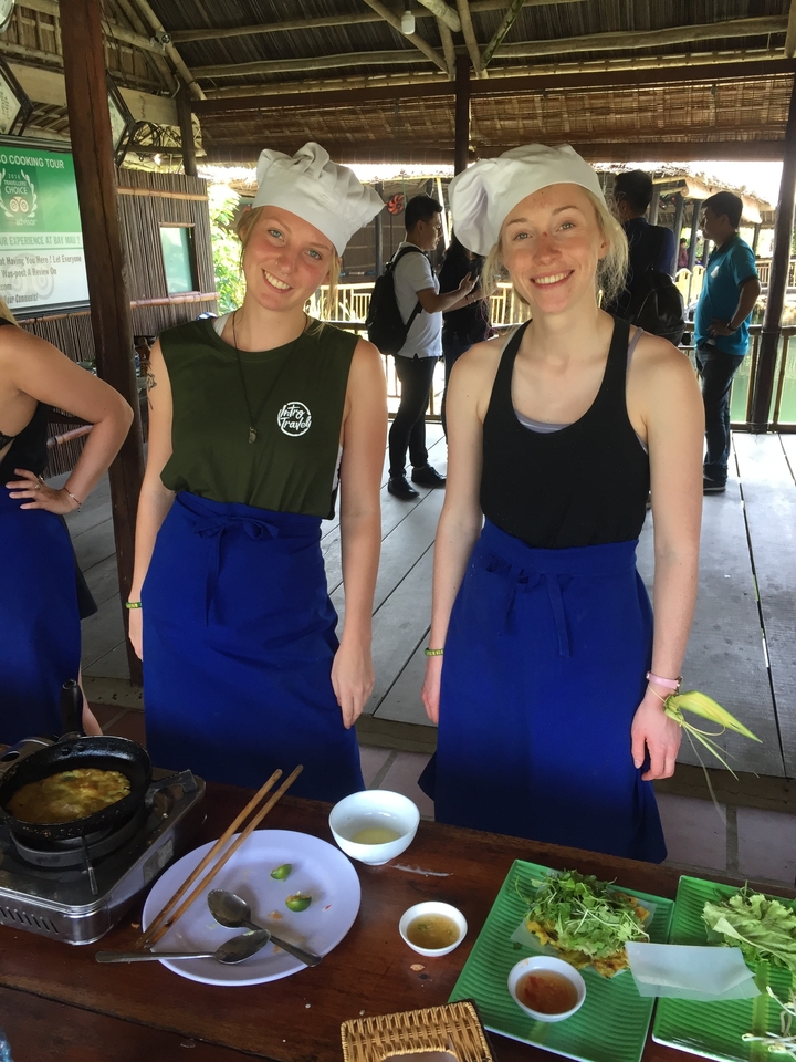 Deux personnes debout côte à côte avec des tabliers.