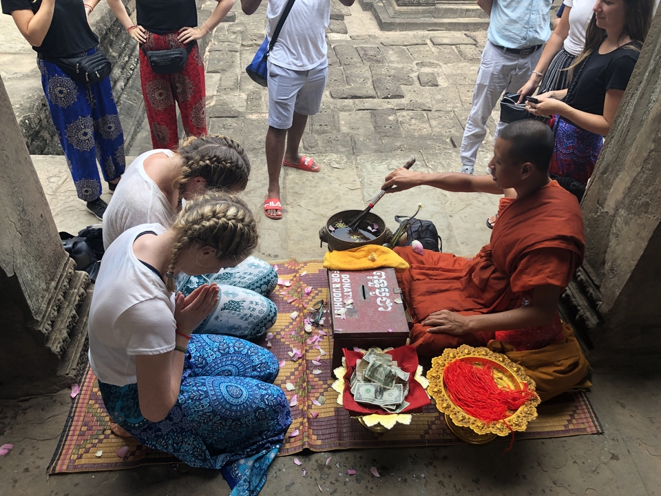 Moine accomplissant une bénédiction avec des gens.