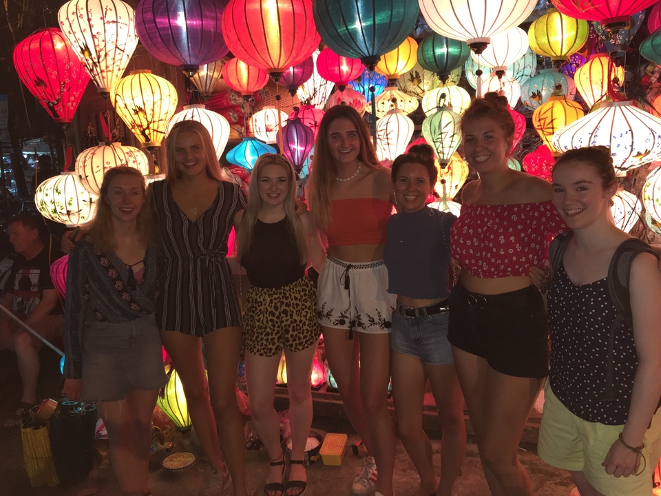 Des personnes posant devant des lanternes colorées.