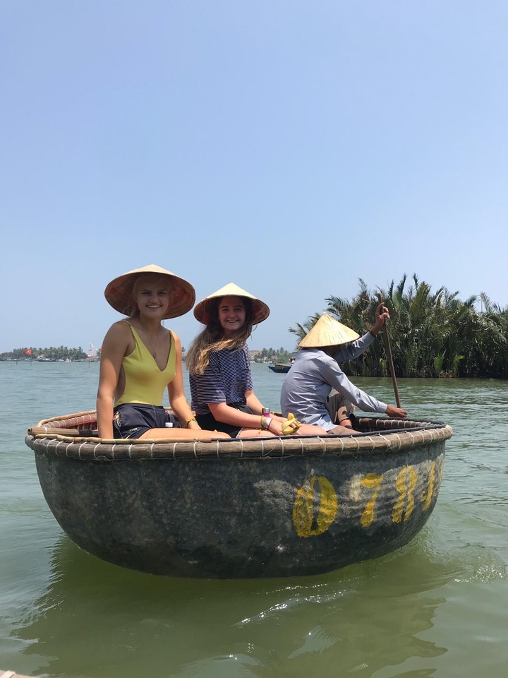 People in a small round boat on a river.