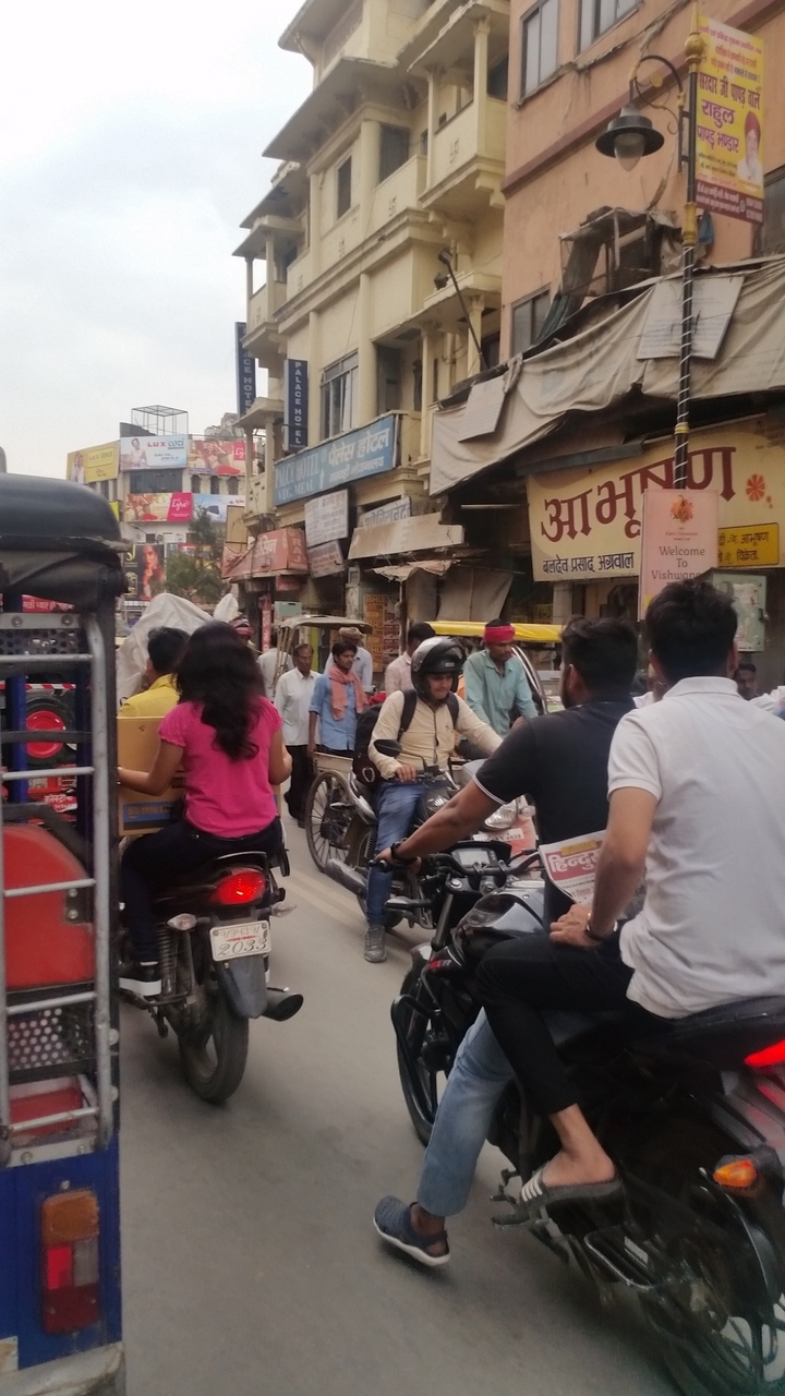 Marché de rue bondé avec des gens et des motos.