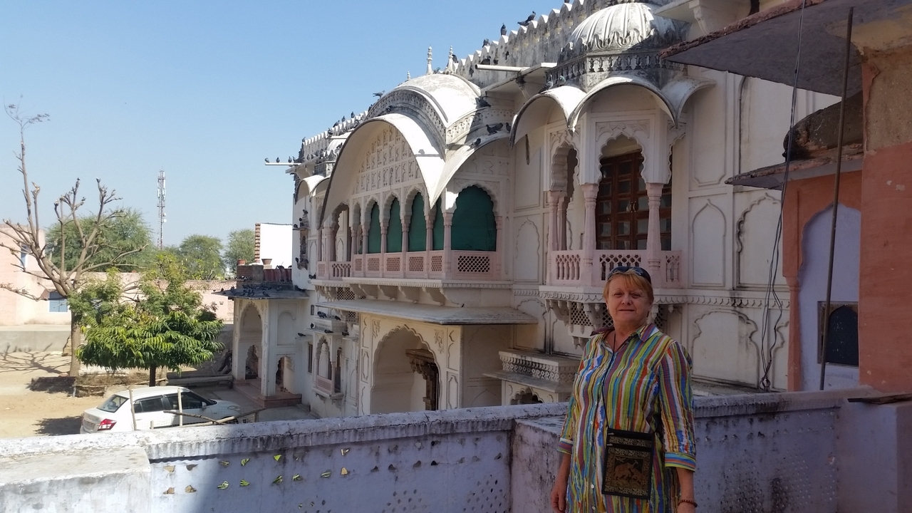 Personne devant un bâtiment traditionnel orné.