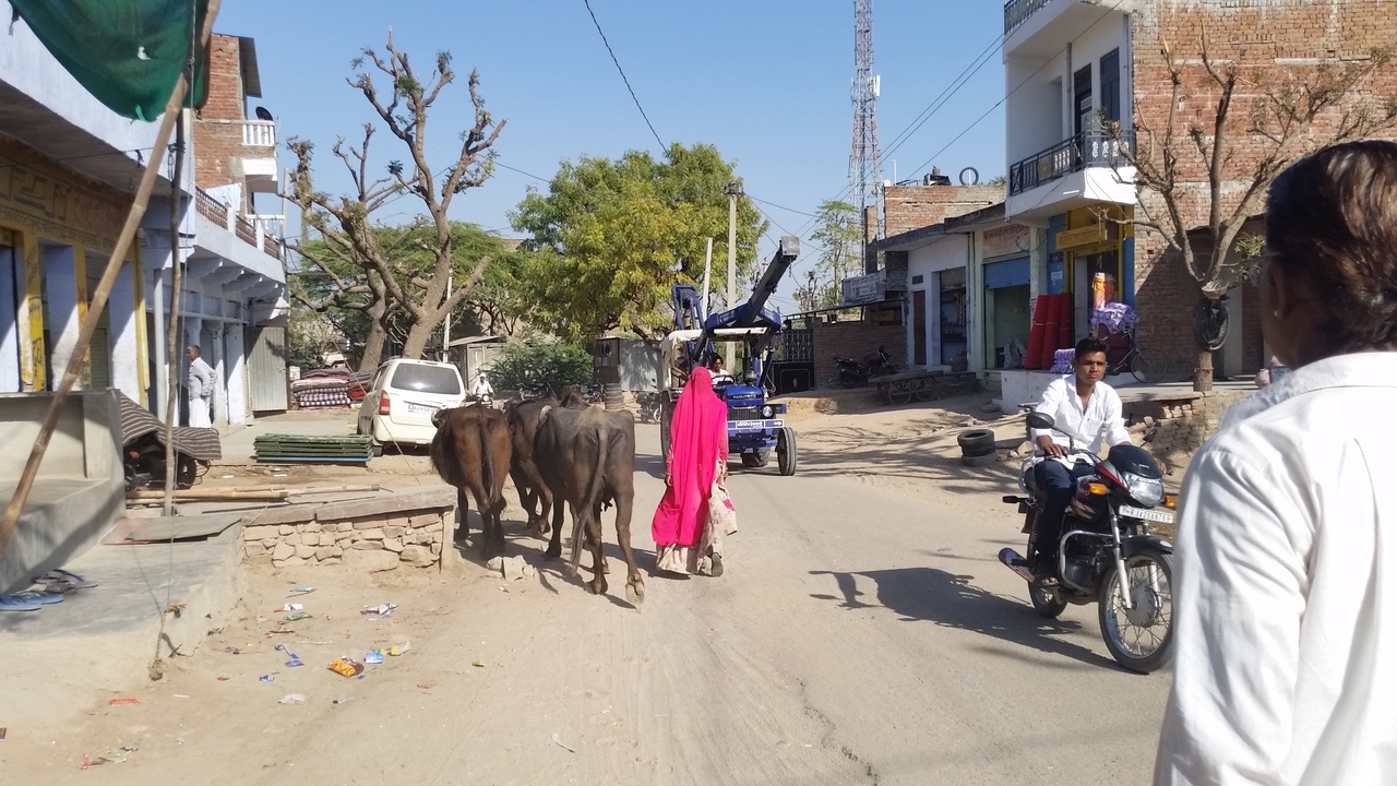 Rue animée avec des résidents et des motos.