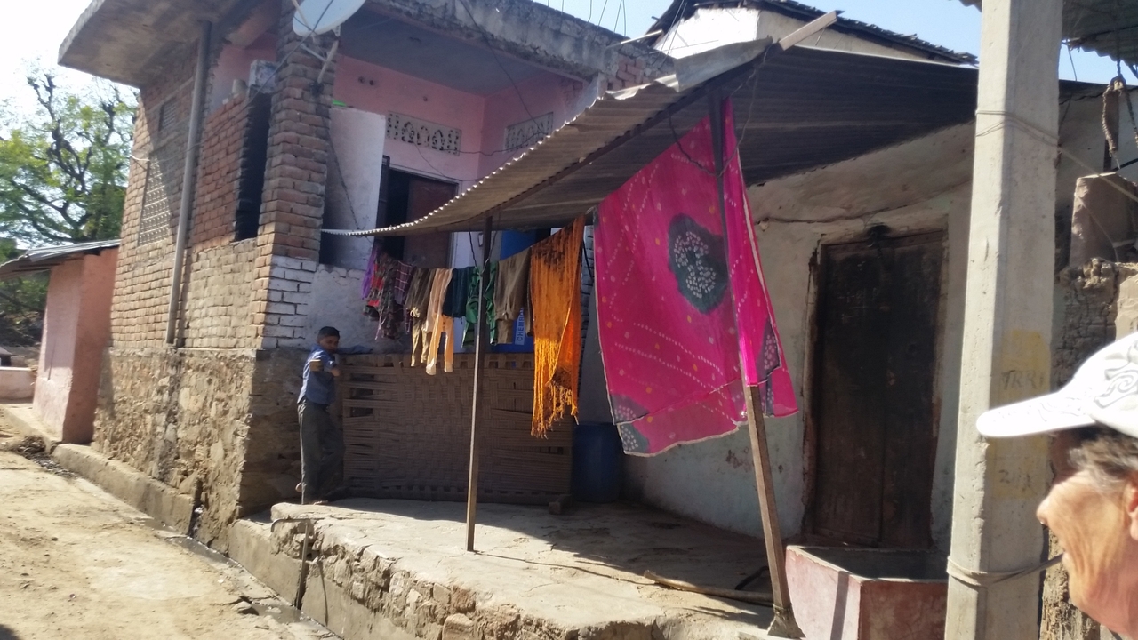 Rue avec un habitant local et des textiles colorés qui pendent.