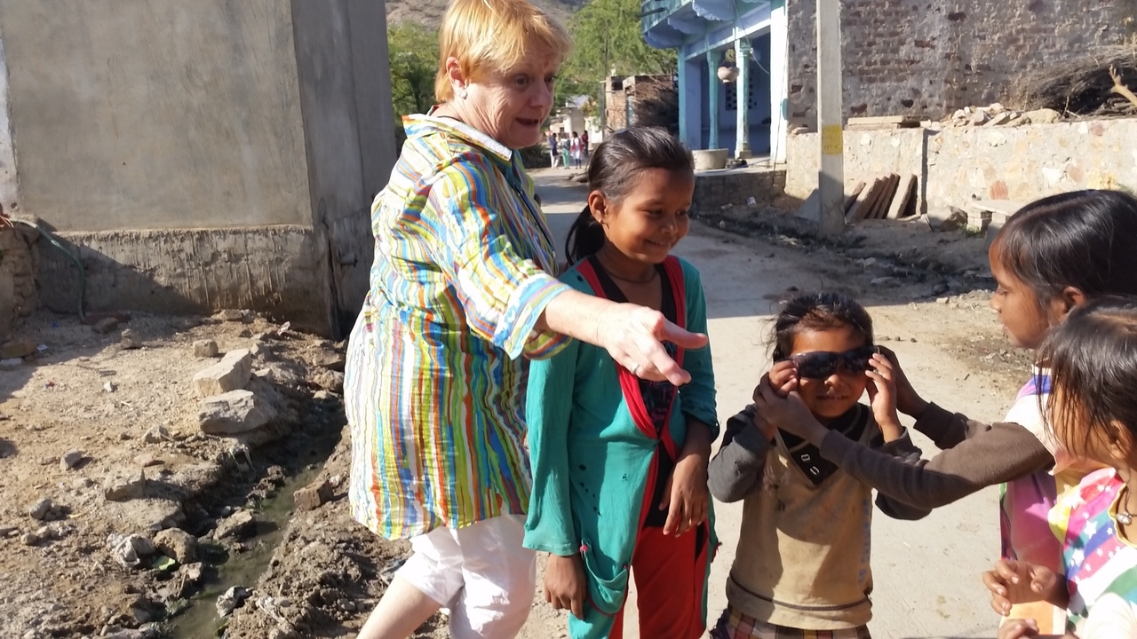 Personne interagissant avec des enfants dans un cadre de rue.