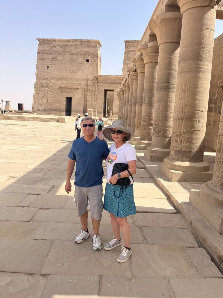 Des touristes prenant la pose sur un site archéologique ancien avec des colonnes.