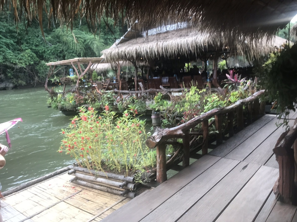 Restaurant rustique au bord de l'eau avec des structures en bois.