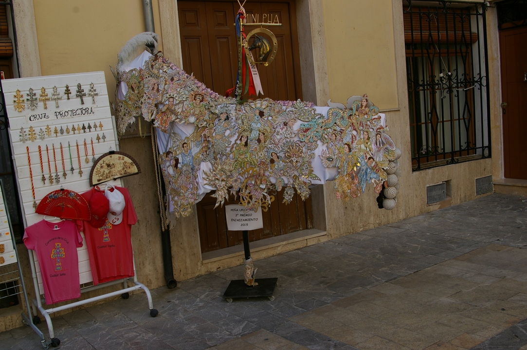 Étal de marché en plein air avec des tissus colorés et des ornements.
