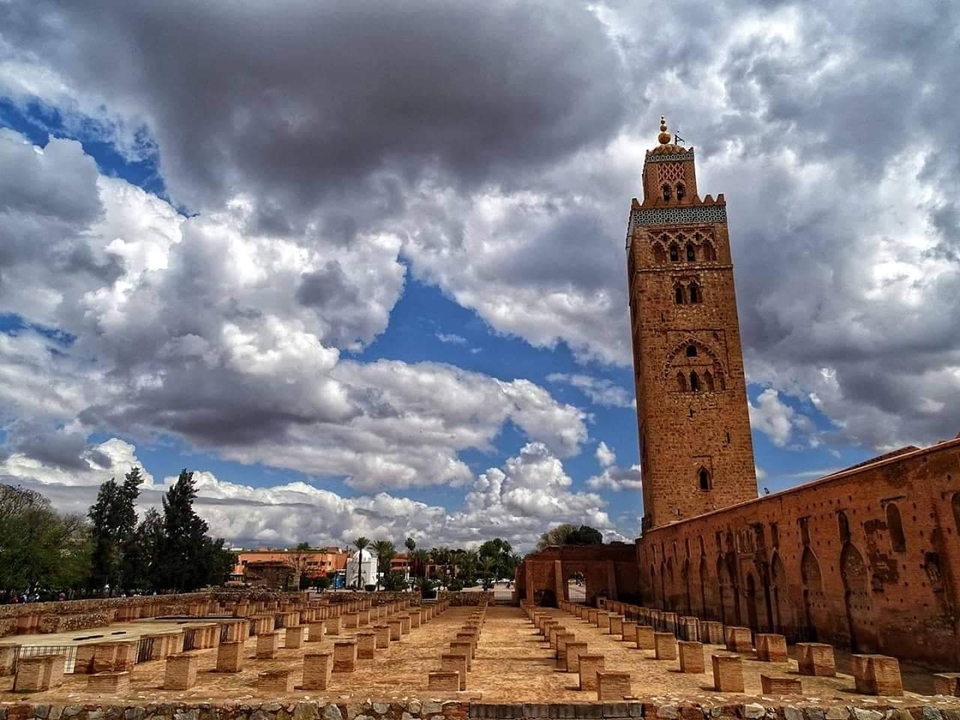 Une tour de mosquée historique sous un ciel nuageux.