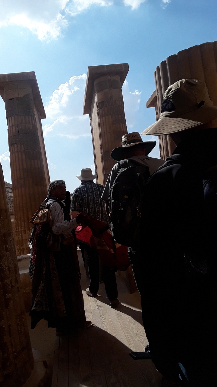 Des touristes explorant d'anciennes colonnes dans un site historique.