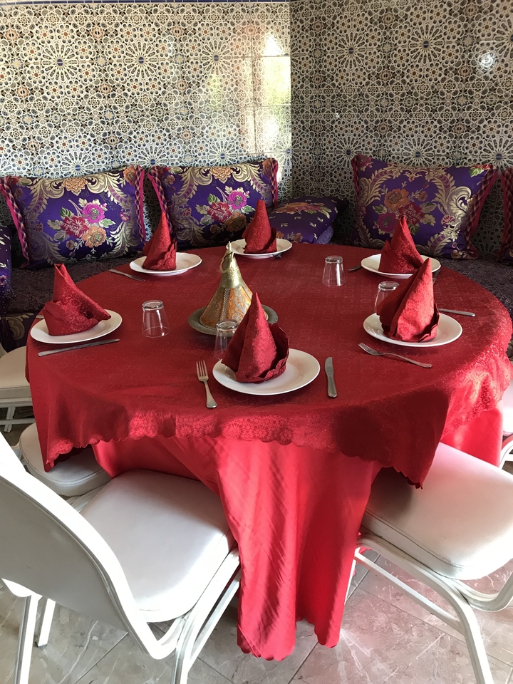 Configuration de salle à manger élégante avec des serviettes rouges et de la vaisselle traditionnelle.