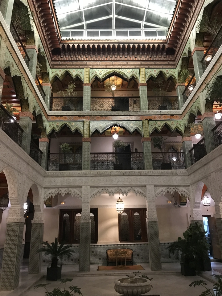 Vue intérieure d'une belle cour architecturale avec des motifs complexes et de la verdure.