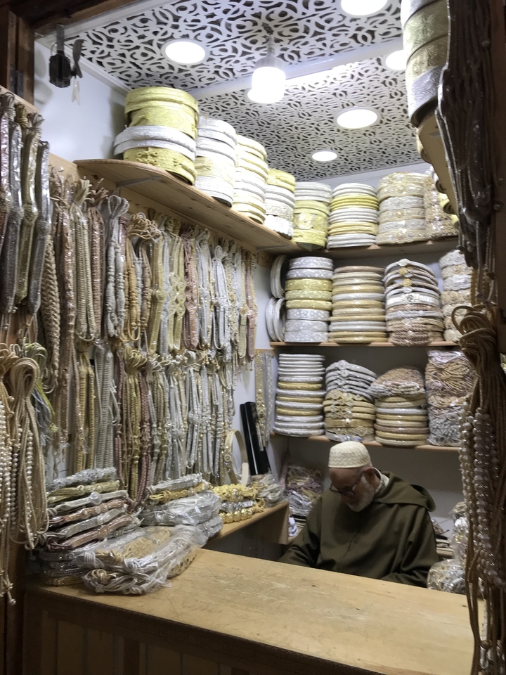 Étagères remplies de cordes décoratives et de galons dans un magasin.