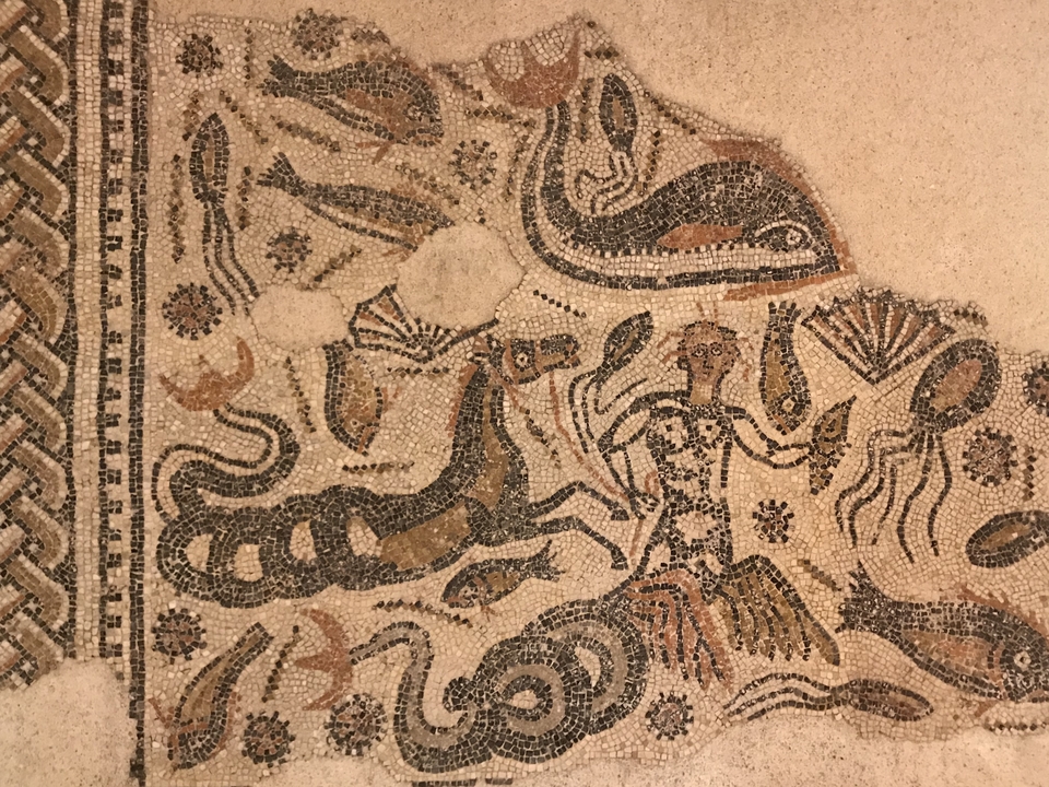 Œuvre d'art en mosaïque représentant des thèmes antiques avec des motifs complexes.