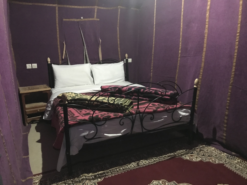 Aménagement de chambre avec murs violets et décoration ethnique.