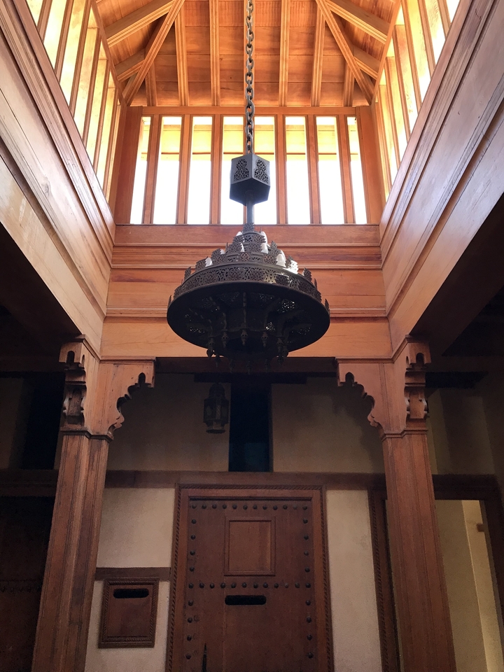 Une lampe marocaine traditionnelle suspendue à un plafond en bois.