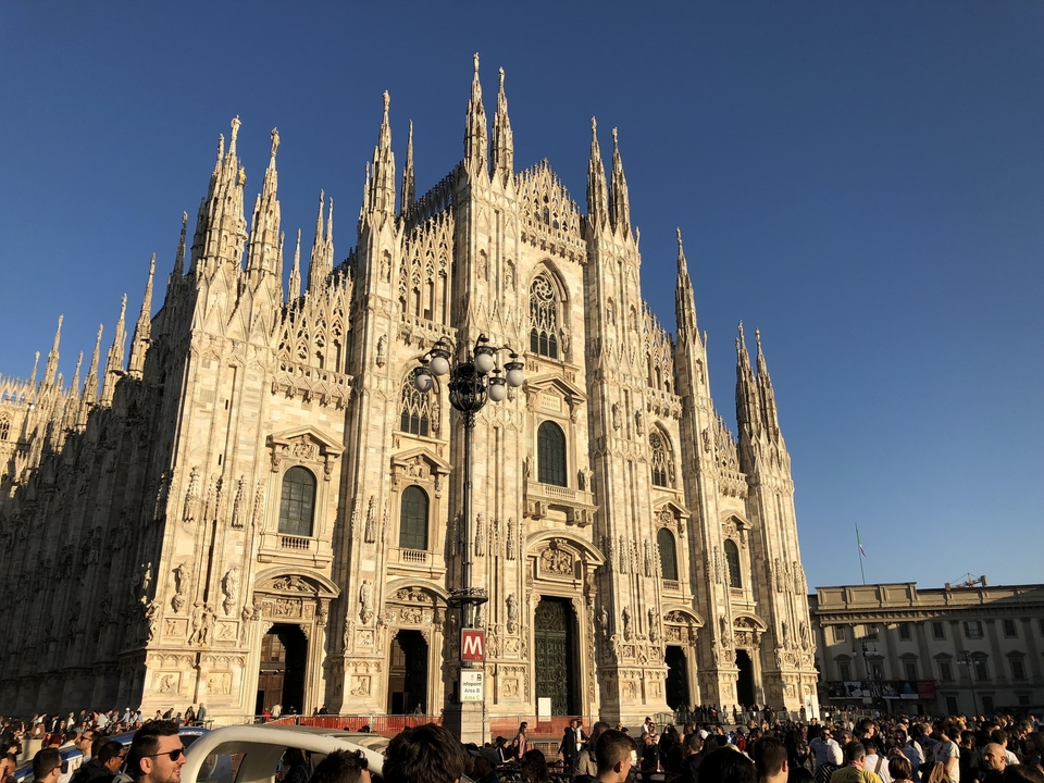 Vue de face de la cathédrale de Milan avec un ciel bleu dégagé.