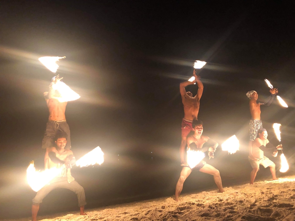 Groupe d'artistes jonglant avec le feu la nuit.