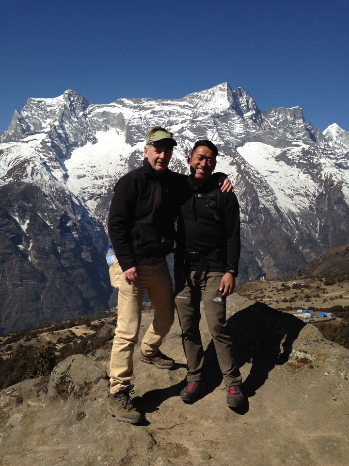 Deux hommes posant devant des montagnes enneigées.