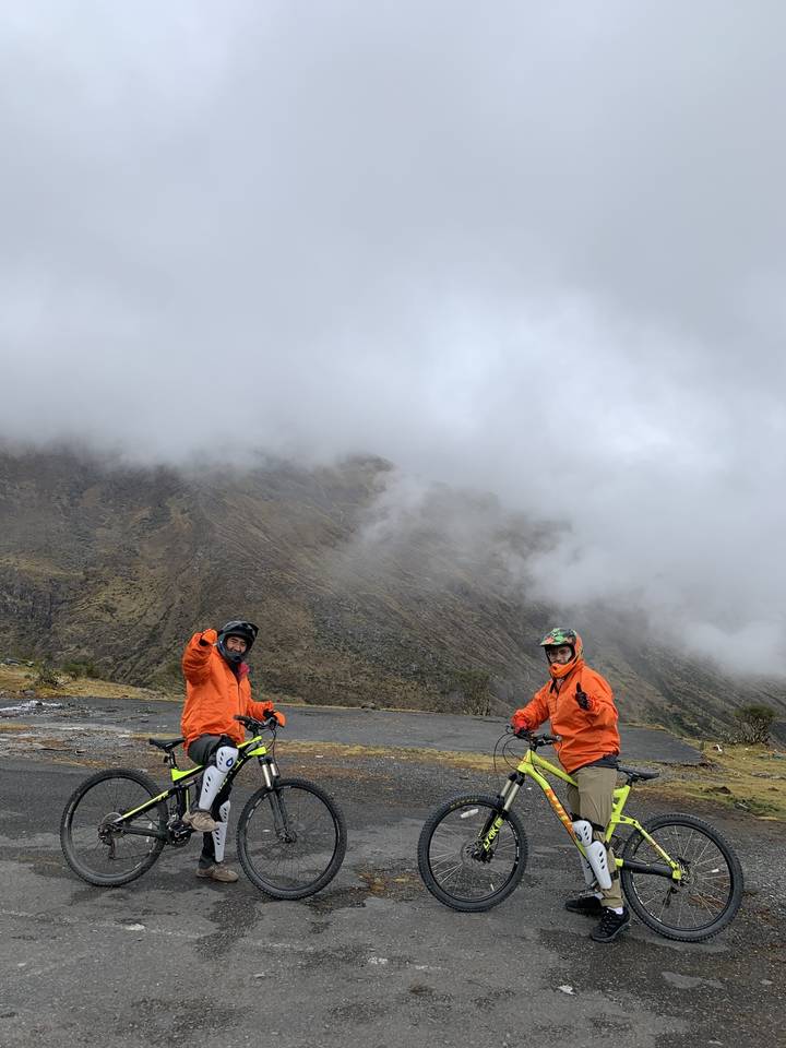 Deux cyclistes sur une route de montagne par temps brumeux.