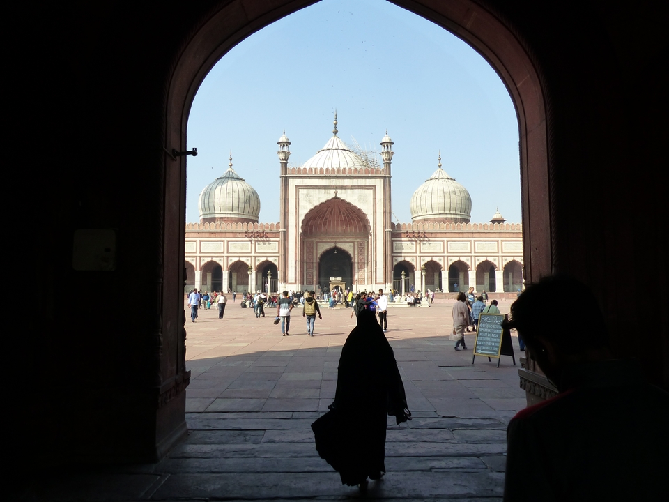 Vue d'une grande mosquée à travers une arcade.